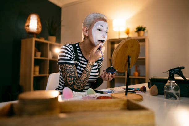 istock Young woman, a mime artist, applying face paint while getting ready for pantomime show. 1782088306