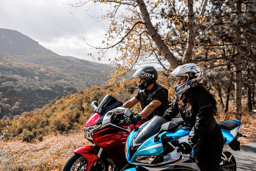 Man and woman, motorcycle riders, enjoys together in nature