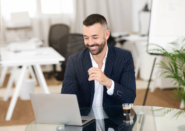 istock Happy confident handsome caucasian mature guy in suit uses laptop for chat, at table with coffee cup 1782099433