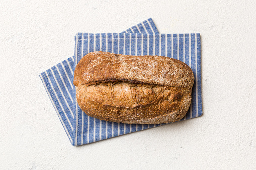 Fresh Homemade Whole Wheat Bread. bread on napkin on rustic background, fresh bread top view.