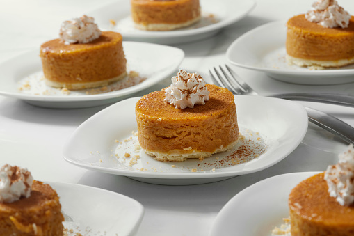Individual Pumpkin Pie's with Whipping Cream and Dusted with Cinnamon