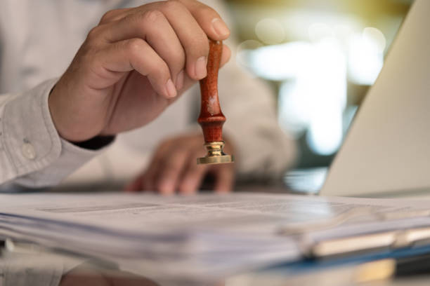 istock Businessman Stamping Approval on a Document certificate or  Official Law Guarantee contract or visa permit on desk 1782109400
