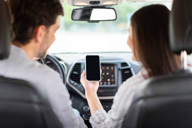istock Happy couple having car trip together, using cell phone, mockup 1782123993