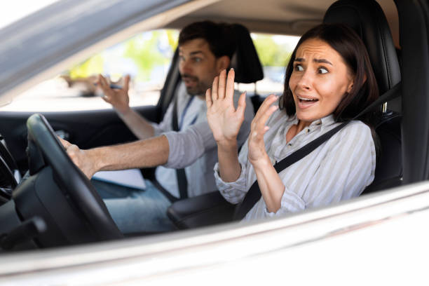 istock Frightened millennial woman driving car with instructor 1782124018