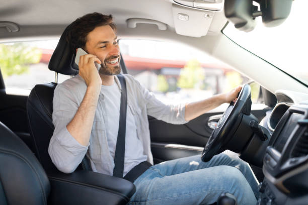 istock Cheerful young man driver talking on phone while driving car 1782125234