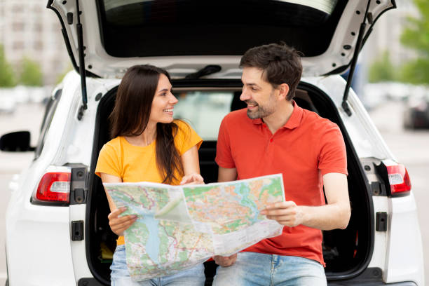 istock Young man and woman having car trip together, reading map 1782125247