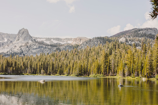 A man peacefully fishing in the middle of a lake at Mammoth Lakes in California