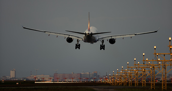 Airplane landing at airport runway in the early morning