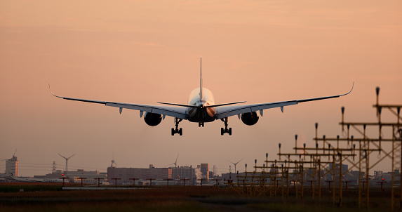 Airplane landing at airport runway in the early morning