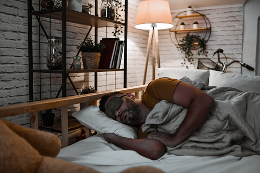 Tired Male Getting Sleep Undisturbed With Eye Mask And Ear Plugs