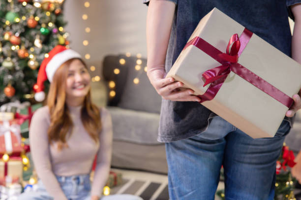 istock Asian Man Hiding a Christmas Present Behide to Surprise his Girlfriend 1782154438