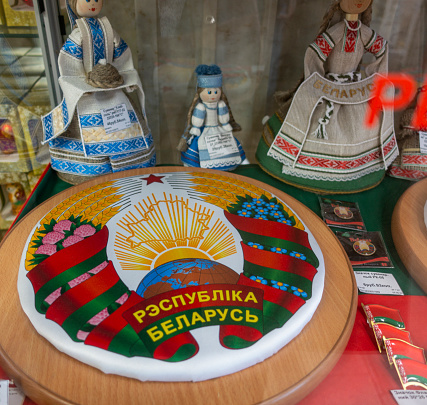 State emblem of Belarus, showcase with Belarusian souvenirs. TEXT TRANSLATION: Republic of Belarus
