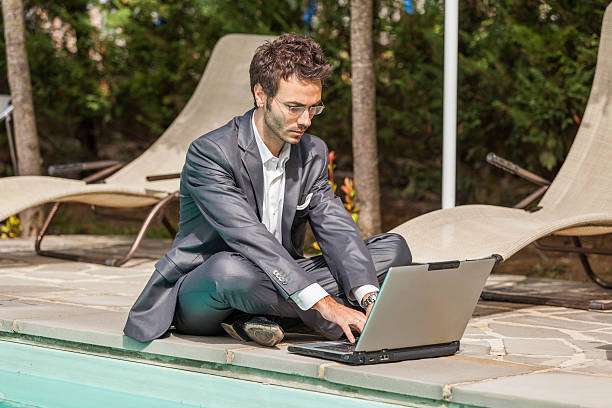 istock Young Businessman with Computer next to Swimming Pool 178217050