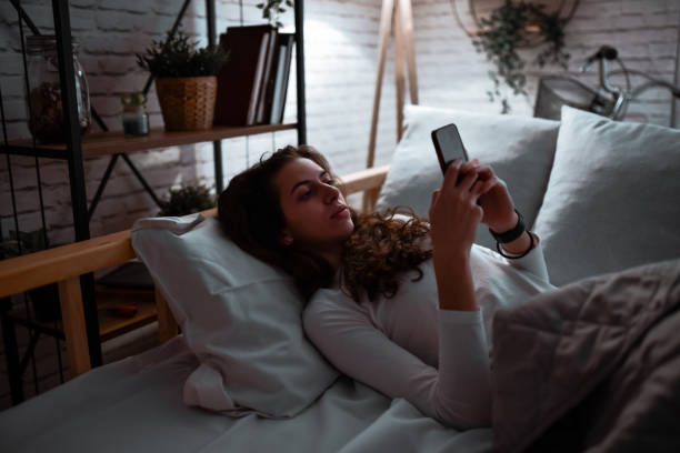 istock Female With Sleeping Disorder Putting Alarm On Smartphone While Getting Ready To Sleep 1782175447