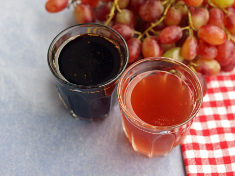 Greek red grapes, grape must (moustos) and grape syrup (petimezi) in glasses