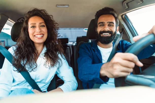 istock Happy middle eastern husband and wife enjoying automobile ride, sitting on front passengers seats, smiling at camera 1782207848
