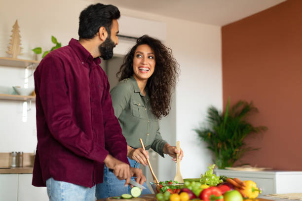 istock Joyful arab spouses cooking dinner and chatting, preparing fresh salad together in kitchen interior, free space 1782209635