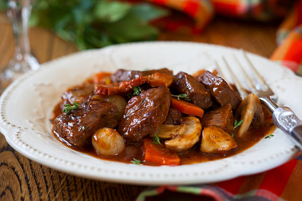 Close-up of Beef Bourguignon served on white plate Traditional Beef Bourguignon braised stock pictures, royalty-free photos & images