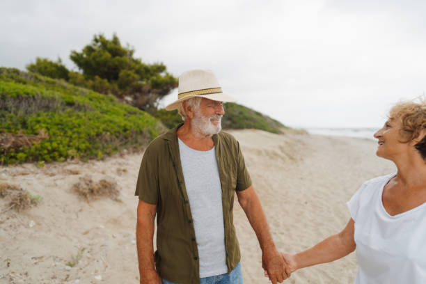 istock Senior couple in a romantic walk down the beach 1782254397