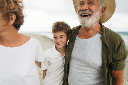 Photo of a senior couple and their grandson enjoy in a vacation holiday by the sea