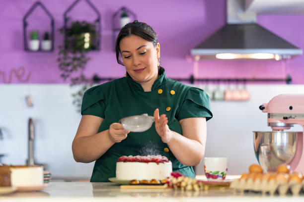 Woman putting sugar on cake