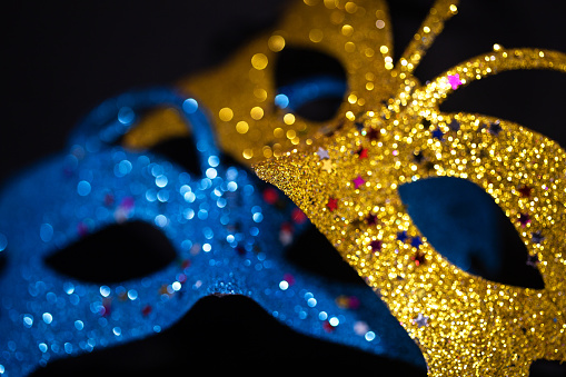 Luxurious Venetian shiny masks on a dark background. Carnival masquerade fantasy mask. Holiday and party concept. Blurred photo