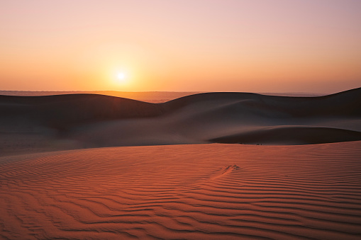 Sand dunes against sky at sunrise. Desert Wahiba Sands in Sultanate of Oman.
