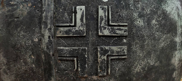 Emblem of the Wehmacht, the Nazi army of World War II. Emblem of the Wehmacht, the Nazi army of World War II. Metal bas-relief of a German cross. Balkenkreuz. Blackened old metal. iron cross stock pictures, royalty-free photos & images