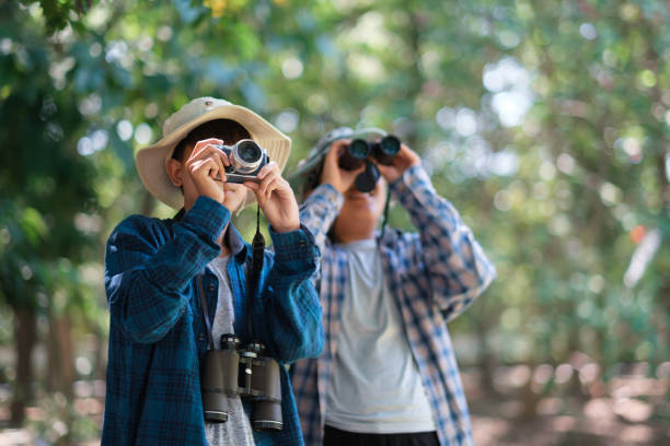 istock Two young boys in the forest hiking and camping. learning about wildlife, using a camera, taking pictures and binoculars to search for animals with friends. Happy smiling excited summer vacation. 1782362594