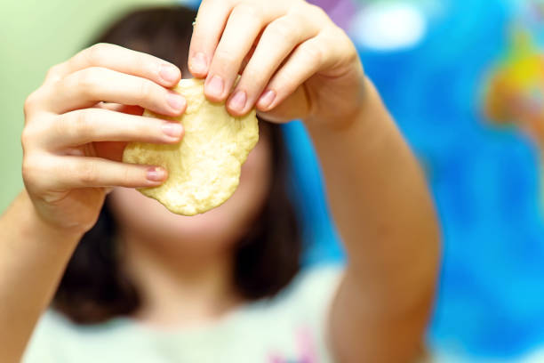istock Child's hands holding raw dough 1782377528