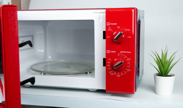 istock An open red microwave placed on the table in kitchen on white background. Kitchen appliances using or cleaning concept. 1782379244