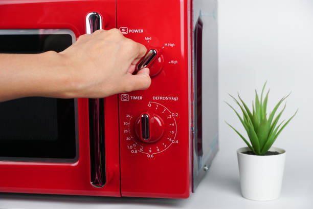 istock Woman's hand adjusts the temperature with a circular button to warm food from the kitchen microwave. kitchen electric appliances using concept. 1782379649