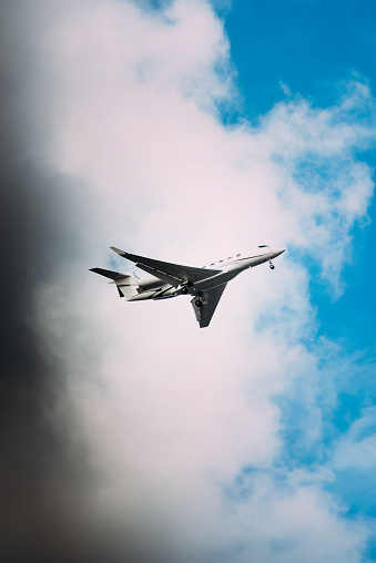 A private luxury jet flying through a cloudy blue sky