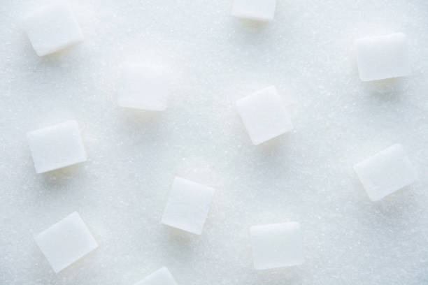 istock White granulated sugar and refined sugar cubes close-up. Sugar textured. 1782446902