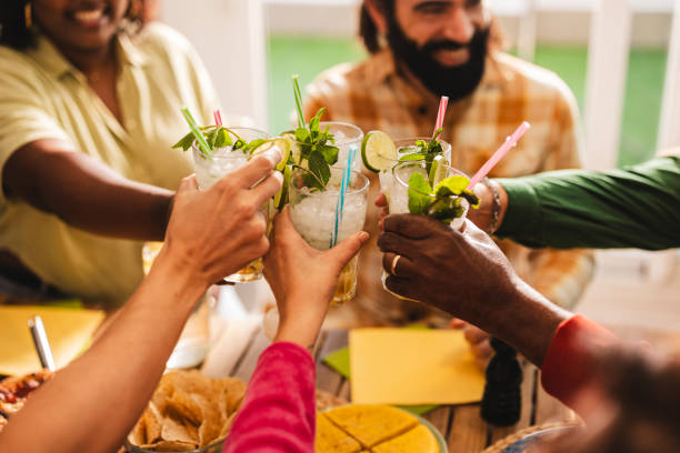 istock Happy friends group cheering mojito drinks at fancy bar restaurant - Young people having fun toasting cocktail glasses enjoying happy hour at rooftop pub - Party time, life style and youth concept 1782457731