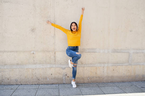 istock Joyful young woman dancing on the street 1782475687