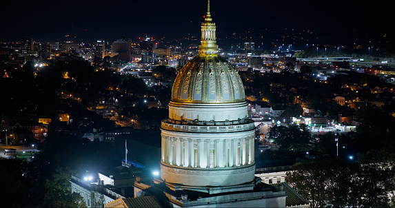A high angle aerial still photo of the West Virginia State Capitol building on a cold, fall night.