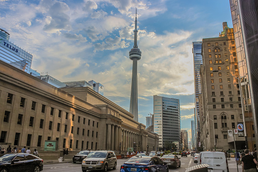 September 2023- Toronto, Canada: View on the Canadian National - CN - Tower (communications tower), taken from downtown Toronto, with Union Station in front. Also features beautiful skies shortly after rain and the beginning of sunset.