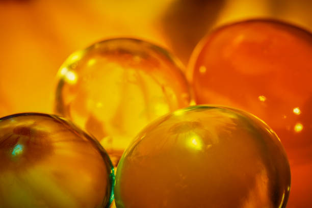 colorful hydrogel balls lie on a curved copper wire with a beautiful reflection of colors , creative macro photography , bright abstract background
