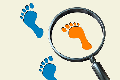 Magnifying glass , footprints background. Investigation and detective concept.