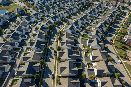 Aerial still image of a residential district with numerous cookie-cutter houses, taken by a drone on a sunny Fall day in Grove City, Ohio.