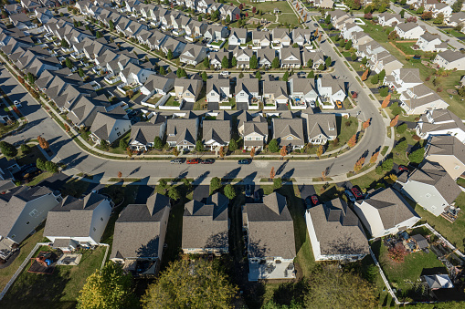 Aerial still image of a residential district with numerous cookie-cutter houses, taken by a drone on a sunny Fall day in Grove City, Ohio.