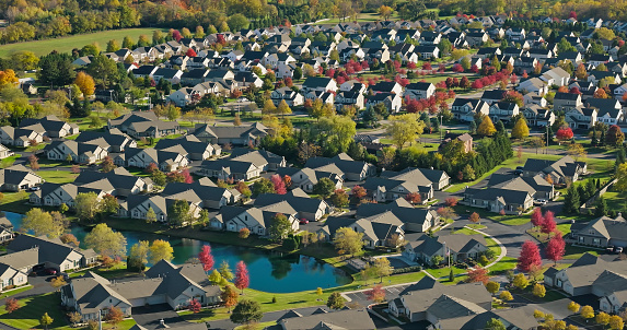 Aerial view of new apartment houses between yellow trees in South Carolina suburban area in fall season. Real estate development in american suburbs.