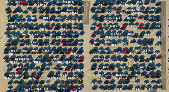 Aerial still image of numerous cars sitting stationary in a massive parking lot on a sunny Fall day in Grove City, Ohio.