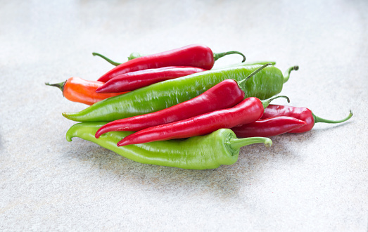 Table top view of red chili peppers in a basket with copy space