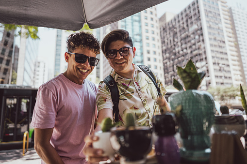 Tourist gay couple buying craft products at a street market