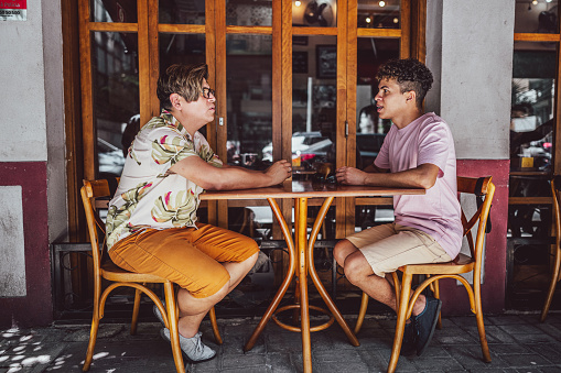 Gay couple talking at a restaurant