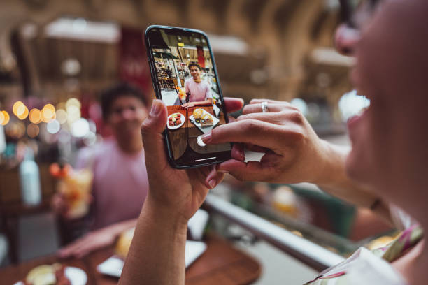istock Tourist gay couple taking a selfie using mobile phone at restaurant 1782601929
