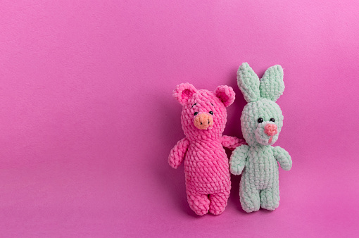 Amigurumi soft toys on a pink background with copy space. Soft Toy Day, holiday. card. Symbol of the new year