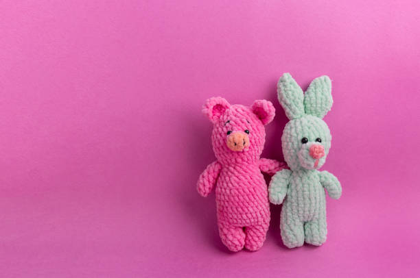 Amigurumi soft toys on a pink background with copy space. Soft Toy Day, holiday. Amigurumi soft toys on a pink background with copy space. Soft Toy Day, holiday. card. Symbol of the new year pink teddy bear stock pictures, royalty-free photos & images